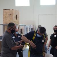 Students suiting up into safety harnesses